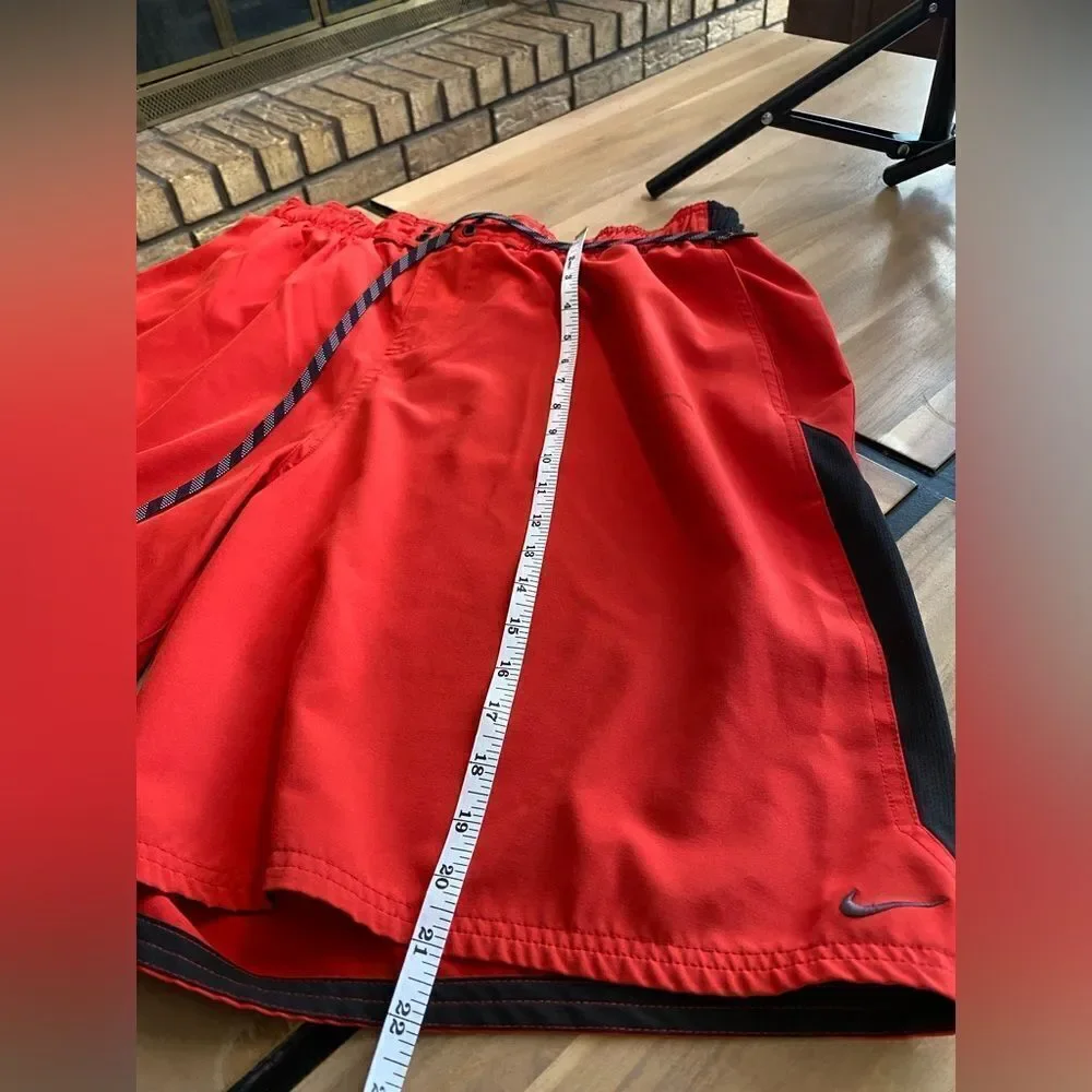 Red and black Nike swim trunks‎
